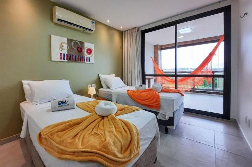 a hotel room with two beds and a large window at Wai Wai Cumbuco Vista Lateral Mar 2 Quartos in Cumbuco