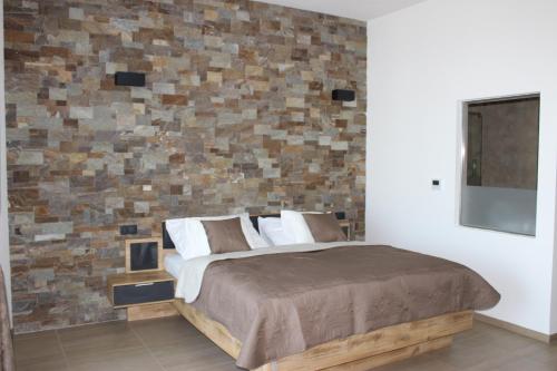 a bedroom with a bed and a brick wall at Johannesberg in Zaječí