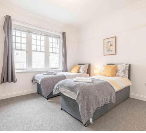 a bedroom with two beds and a window at The Bull Iver Guest House in Slough