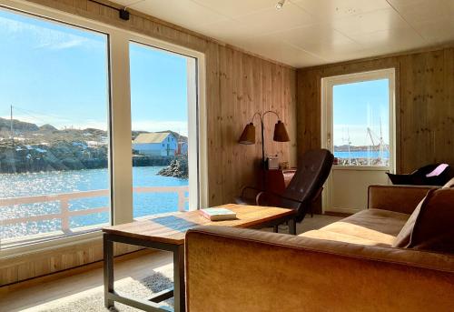 a living room with a couch and a table and a window at Fishermans Dock Lofoten in Ballstad