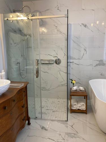 a bathroom with a shower with a glass door at The Red House Fredericton in Fredericton