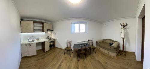 uma cozinha e sala de estar com um sofá e uma mesa em у Михайла em Truskavets