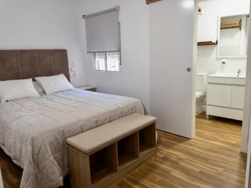 ein Schlafzimmer mit einem Bett und ein Badezimmer mit einem Waschbecken in der Unterkunft Apartamento de Julia in Córdoba
