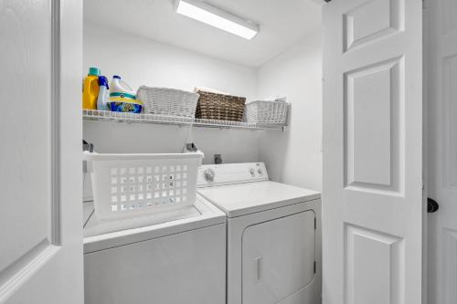 a white laundry room with a washer and dryer at Sand Castle Tower & Cabana in Panama City Beach