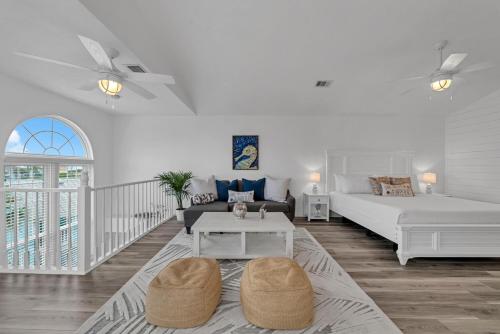 ein weißes Wohnzimmer mit einem Bett und einem Tisch in der Unterkunft Sand Castle Tower & Cabana in Panama City Beach