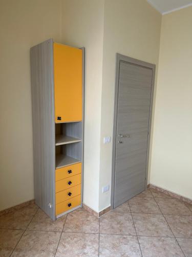 a closet with a yellow cabinet and a door at Appartamenti Estivi in Cirò Marina