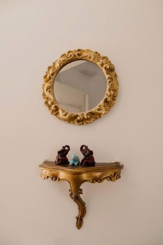 a mirror on a wall with two teddy bears on a shelf at Elephant in my room in Dubrovnik
