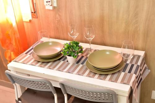 un tavolo con piatti e bicchieri da vino sopra di [Milan sweet home] Metro, Linate e Sky studio a Milano