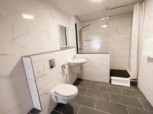 a white bathroom with a toilet and a sink at Blue Lagoon in Nehren