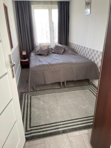 niewielka sypialnia z łóżkiem i oknem w obiekcie White Apartment w Iwoniczu-Zdroju