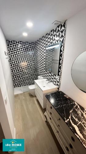 La salle de bains est pourvue d'un mur noir et blanc à motifs. dans l'établissement 180 home Luxury Redes, à Séville