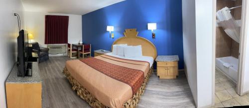 a hotel room with a large bed and a bathroom at Travelodge by Wyndham Junction City in Junction City