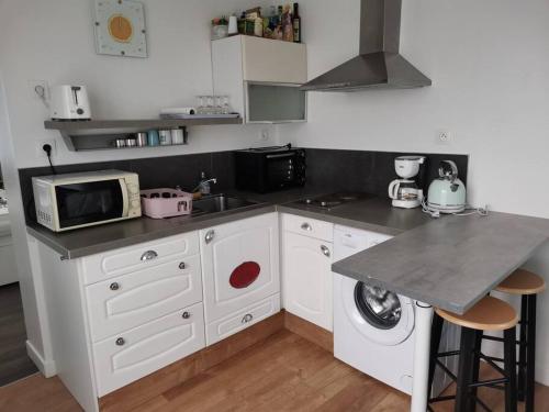a kitchen with a sink and a microwave at Charmante maisonnette. in Brest
