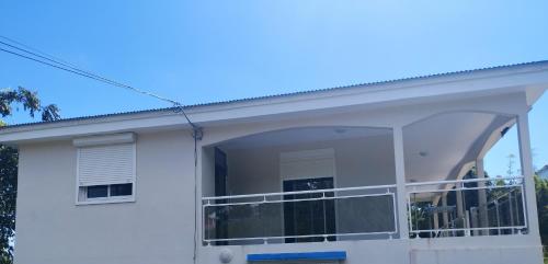 una casa bianca con una grande finestra e un balcone di VILLA JAGUAR a Le Gosier