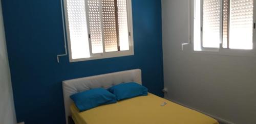 um quarto azul com uma cama com duas almofadas azuis em VILLA JAGUAR em Le Gosier