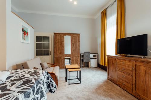 a bedroom with a bed and a flat screen tv at Botanický dvor in Banská Štiavnica