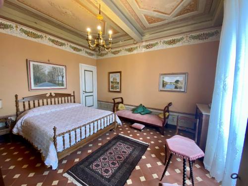 um quarto com uma cama e um lustre em B&B La Rocca em Carmignano