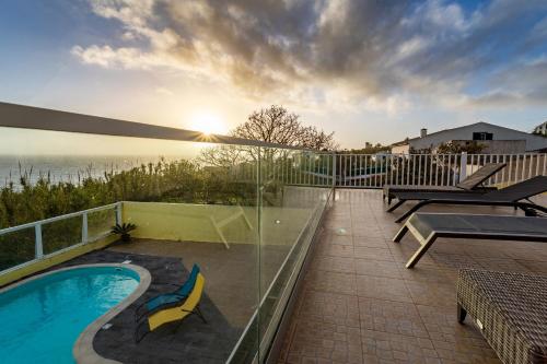 a patio with a swimming pool on a balcony at Whale Song in Feteiras
