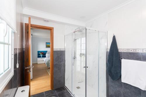a bathroom with a shower and a glass shower stall at Whale Song in Feteiras