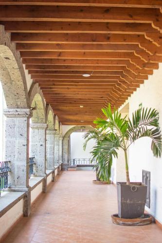a hallway with a wooden ceiling with two plants at Hotel Hacienda la Venta in San Juan del Río