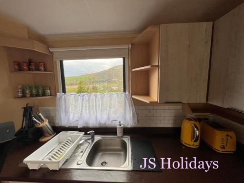 a small kitchen with a sink and a window at JS Holidays The Westmorland Lagganhouse in Ballantrae