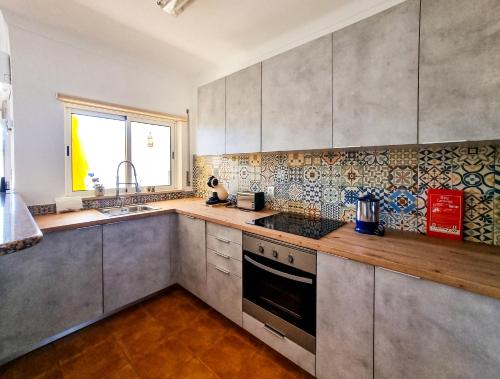 uma cozinha com utensílios de aço inoxidável e uma janela em FLH Carvoeiro Beach Place with Terrace em Carvoeiro