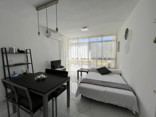 a bedroom with a bed and a desk and a window at Apartamento con piscina y barbacoa in Cala del Moral