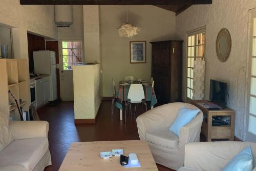 - un salon avec deux canapés blancs et une table dans l'établissement Belle maison familiale indépendante avec jardin., à Vielle-Saint-Girons