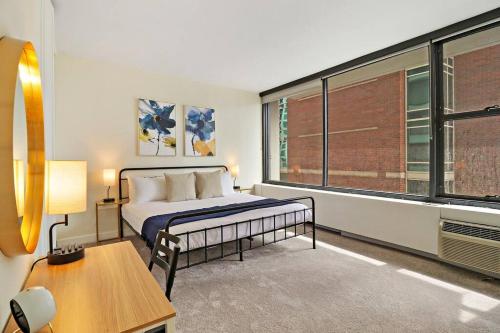 um quarto com uma cama, uma secretária e uma janela em Charming 1BR Unit Great Location - Chestnut 19H em Chicago