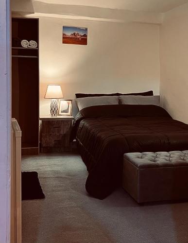 a bedroom with a bed and a ottoman in it at Montana Inn in Wadi Musa