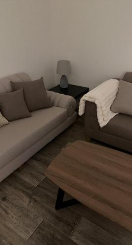 ein Wohnzimmer mit einem Sofa und einem Tisch in der Unterkunft شقق البيت المفروشة in Al Bad‘