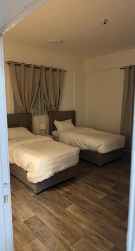 2 Betten in einem Zimmer mit Holzböden in der Unterkunft شقق البيت المفروشة in Al Bad‘