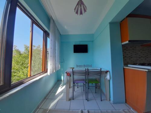 a kitchen with a table and chairs in a room at KESKINEL apart daire in Amasra