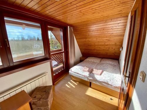 um pequeno quarto com uma cama e uma janela em Chata pod Gerlachom em Stôla
