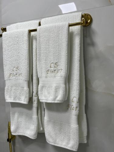 3 toallas blancas colgando de un perchero en un baño en Flat Excepcional no Centro de Capivari, en Campos do Jordão