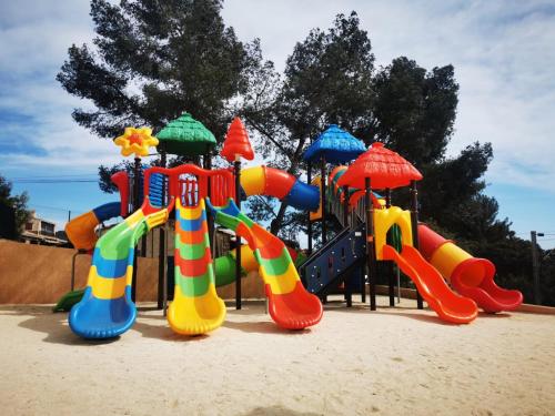 - une aire de jeux avec des équipements de jeux colorés dans le sable dans l'établissement Mobil home neuf camping l ile dor plage st raphael avec piscine, à Saint-Raphaël