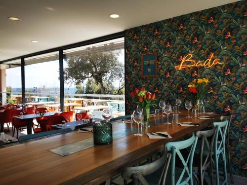 un restaurant avec une longue table en bois et des fleurs sur le mur dans l'établissement Mobil home neuf camping l ile dor plage st raphael avec piscine, à Saint-Raphaël