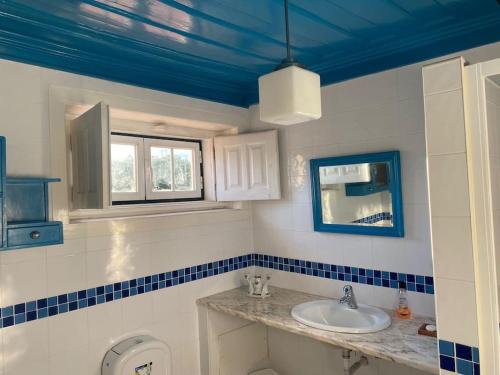 een badkamer met een wastafel en een blauw plafond bij Casa da Ponte, Coja in Coimbra