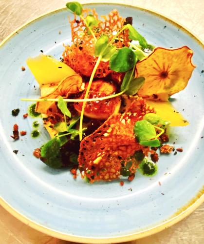 a white plate with food on a table at Mingarry Park in Acharacle