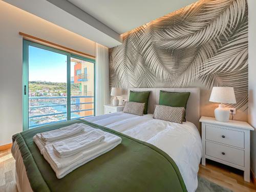 una camera da letto con un grande letto con una grande finestra di Luxury 1 Bedroom Apartment, Marina de Albufeira3 ad Albufeira