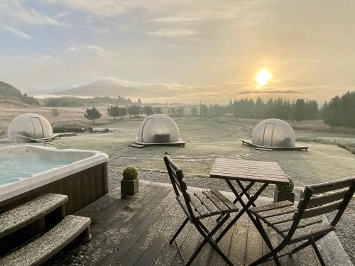 a hot tub with two domes and a table and chairs at Mingarry Park in Acharacle