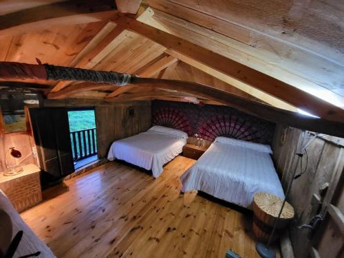 an attic bedroom with two beds in a cabin at Casa Verde. in Villaviciosa