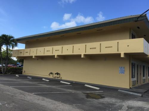 a yellow building with a lot at Curtis Inn & Suites in Hollywood