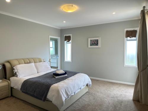 una camera da letto con un letto con pareti e finestre bianche di 99e 5-bedrooms luxury house a Hamilton