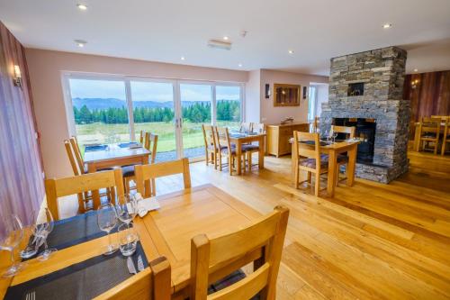 a dining room with a table and a fireplace at Mingarry Park in Acharacle