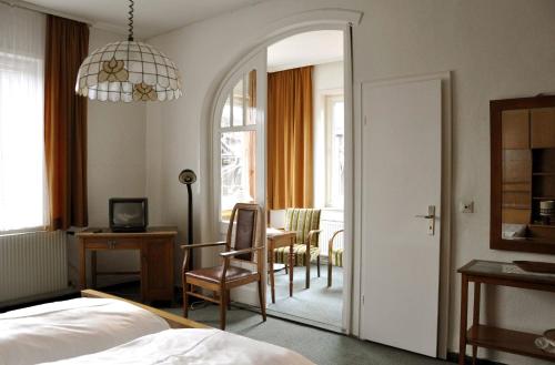 a bedroom with a table and a chair and a mirror at Haus Dümling in Braunlage