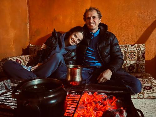 a man and woman sitting on a couch next to a fire at Montana Inn in Wadi Musa