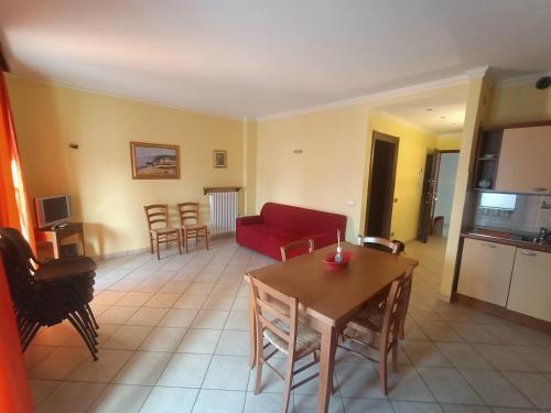 a living room with a red couch and a table at Appartamenti Lungomare Savona in Savona