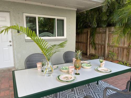 einen Tisch mit Tellern und Gläsern und eine Pflanze darauf in der Unterkunft Luxury Home Steps to Madeira Beach in St Pete Beach