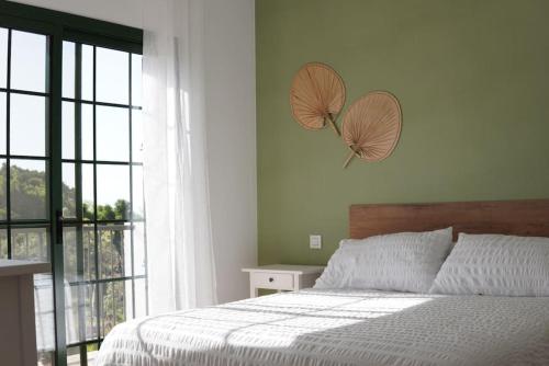 een slaapkamer met een bed en 2 parasols aan de muur bij Casa Notas de Color Y Sal in Agaete